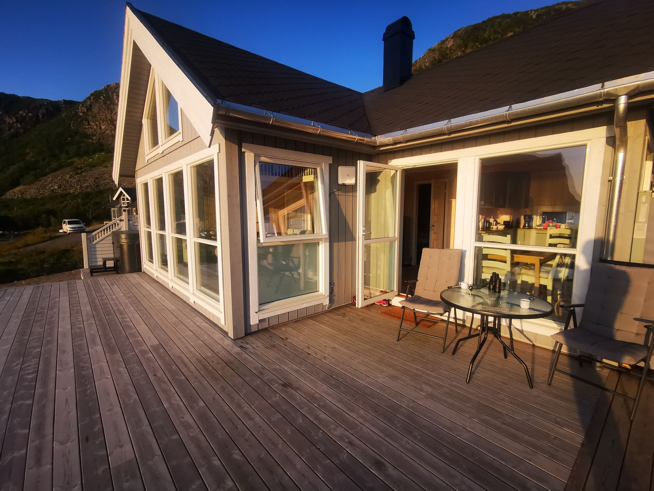 The terrace and the cabin's big windows in the evening sun